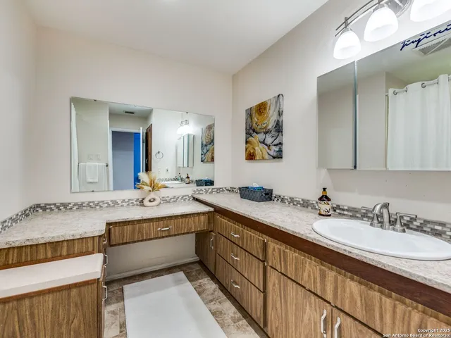 a bathroom with a granite countertop sink mirror and double
