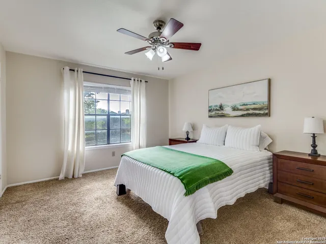 a spacious bedroom with a bed and ceiling fan