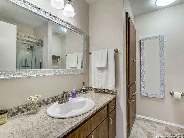 a bathroom with a granite countertop sink and a mirror