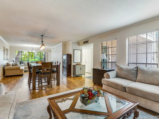 a living room with furniture kitchen view and a large window