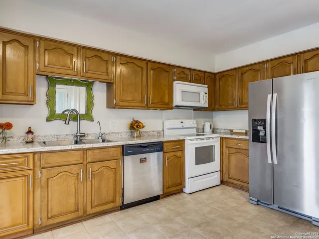 a kitchen with stainless steel appliances granite countertop a refrigerator sink and stove