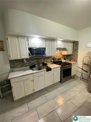 a kitchen with granite countertop a stove sink and cabinets