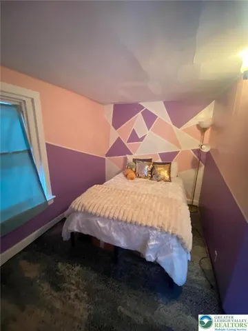 a bed sitting in a bedroom next to a window