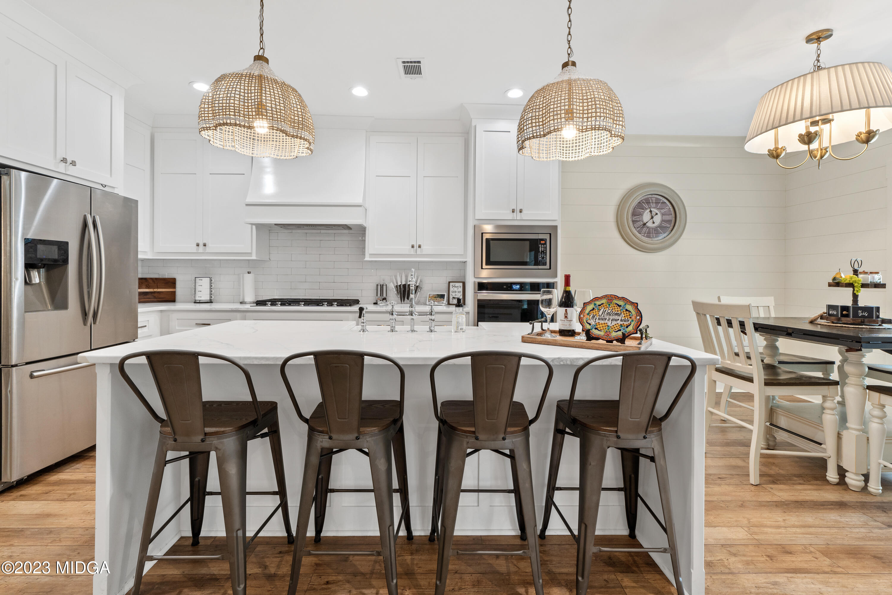556 Pea Ridge Road Juliette, GA 31046 - Photo 6 of 42 a kitchen with stainless steel appliances kitchen island granite countertop a dining table chairs and white cabinets