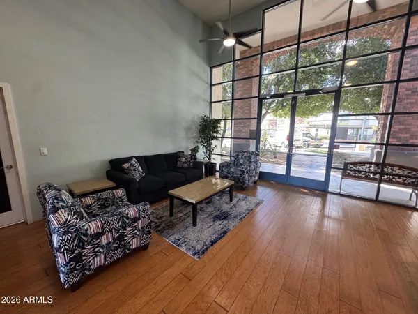 a living room with furniture a wooden floor and next to a window