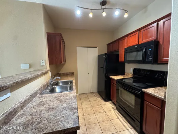a kitchen with stainless steel appliances granite countertop a stove a sink and a microwave