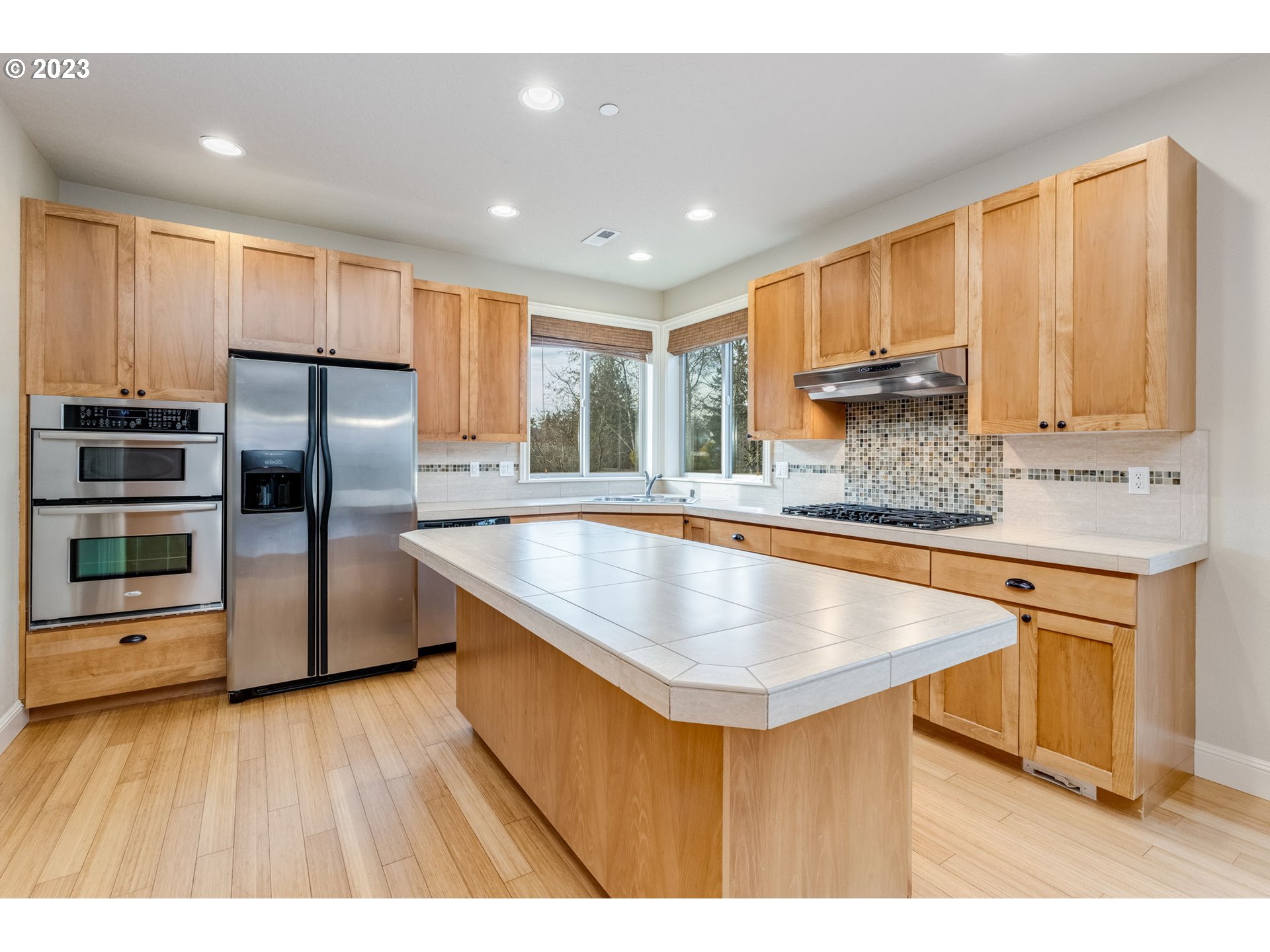 841 Northwest Sacajawea Place Camas, WA 98607 - Photo 9 of 48 a kitchen with stainless steel appliances granite countertop a sink a stove a refrigerator a center island and wooden cabinets