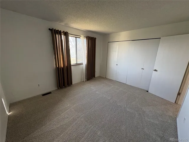 an empty room with windows and closet