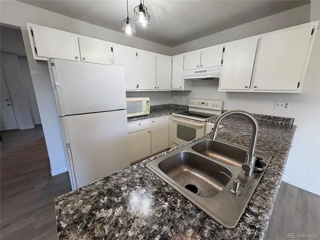 a kitchen with a refrigerator sink and cabinets