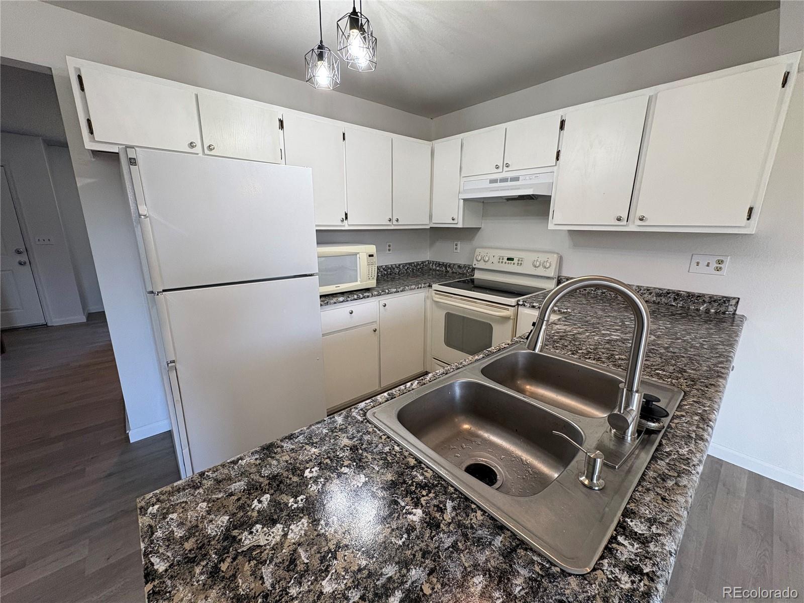 5505 Mansfield Court Colorado Springs, CO 80918 - Photo 4 of 14 a kitchen with a refrigerator sink and cabinets