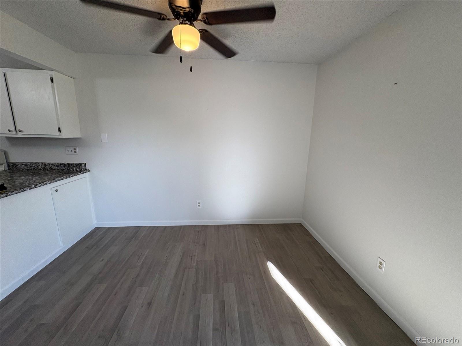 5505 Mansfield Court Colorado Springs, CO 80918 - Photo 6 of 14 a view of an empty room with window and wooden floor