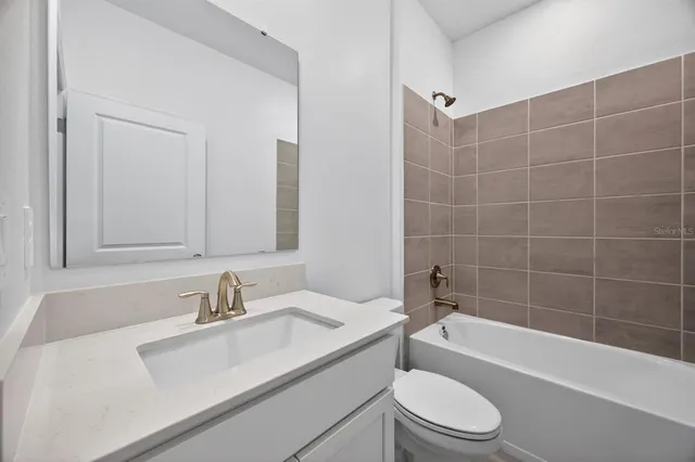 a bathroom with a sink toilet vanity and bathtub