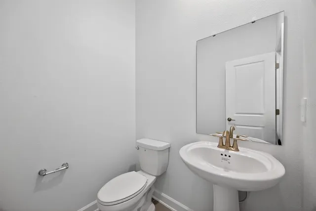 a bathroom with a sink a toilet and mirror