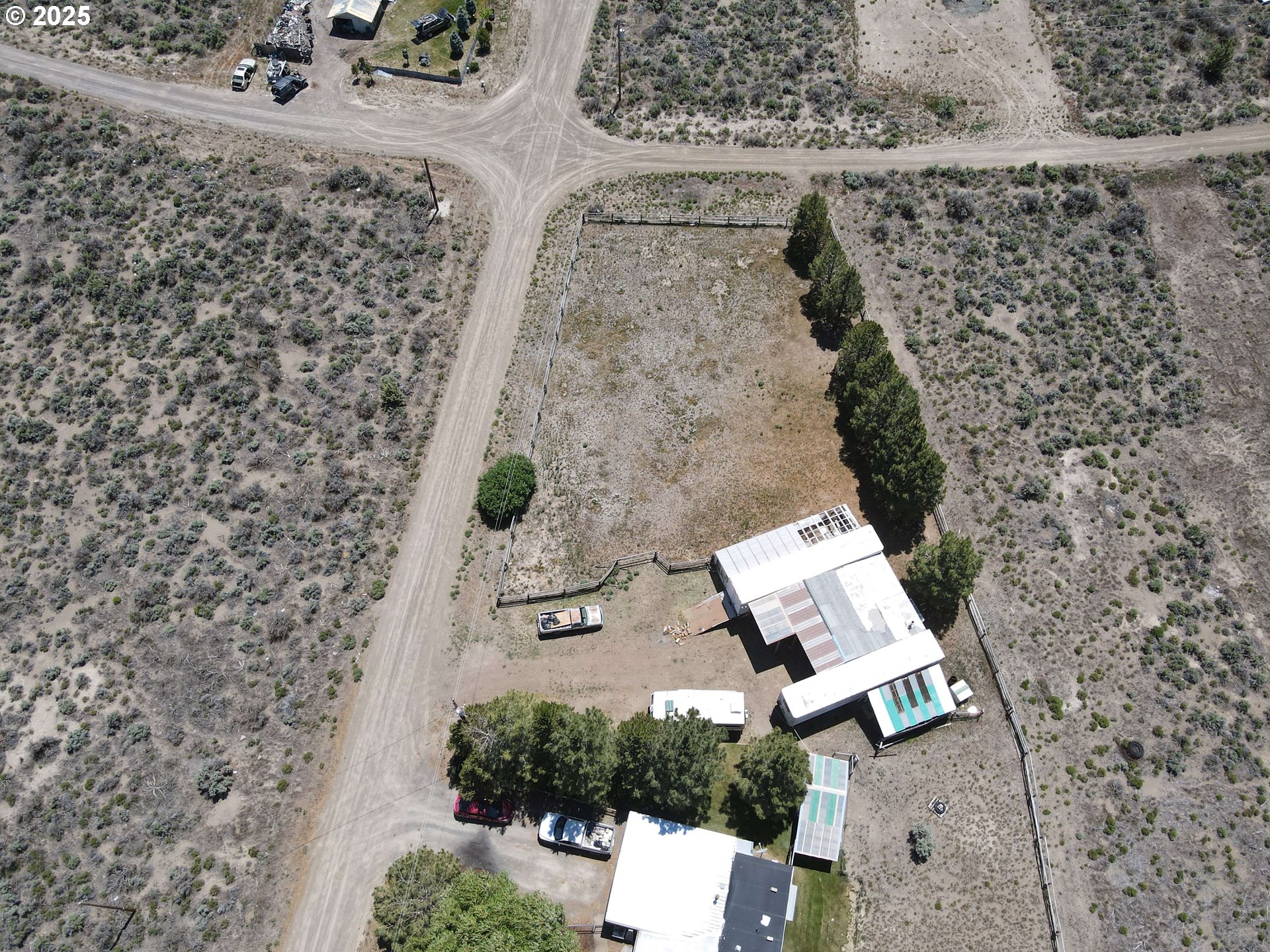 57580 Fall Road Christmas Valley, OR 97641 - Photo 32 of 38 an aerial view of a house with a yard and wooden fence