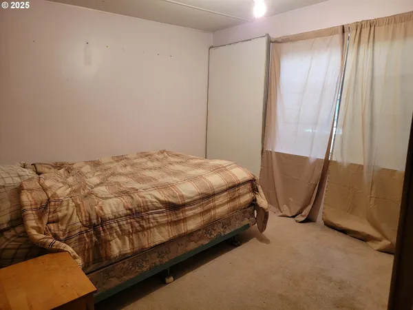 a bed sitting in a room next to a shower curtain