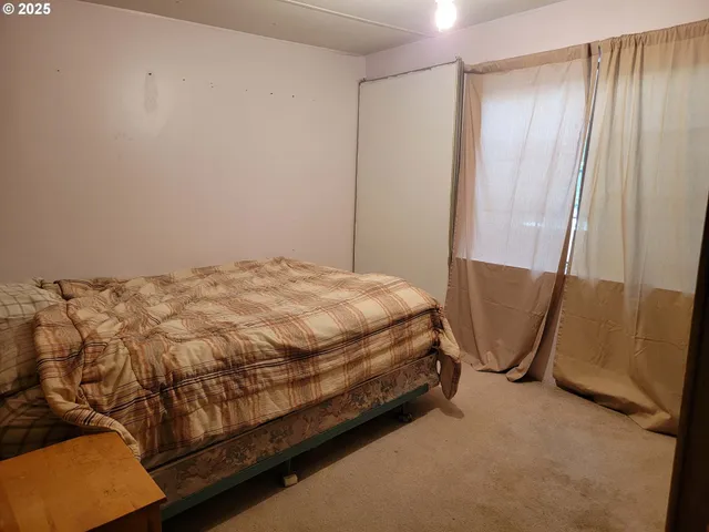 a bed sitting in a room next to a shower curtain