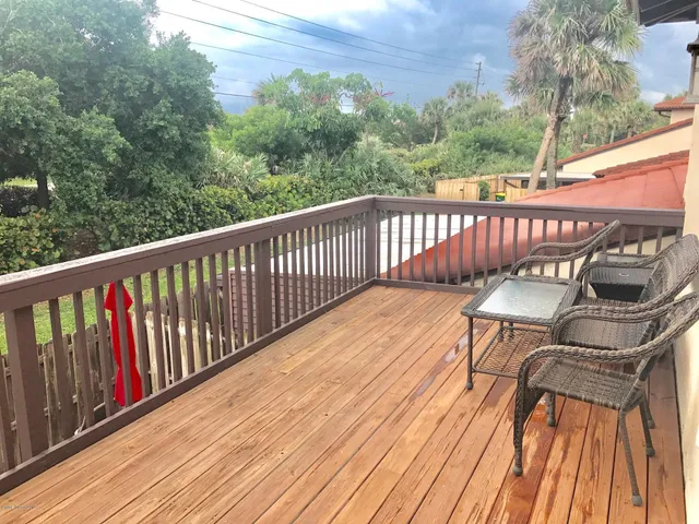 a view of a balcony with wooden floor and fence