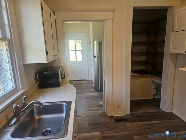 a room with a walk in closet and wooden floor