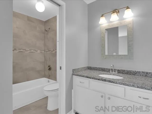 5978 Rancho Mission Road, Unit 264 San Diego, CA 92108 - Photo 9 of 22 a bathroom with a granite countertop sink toilet and shower