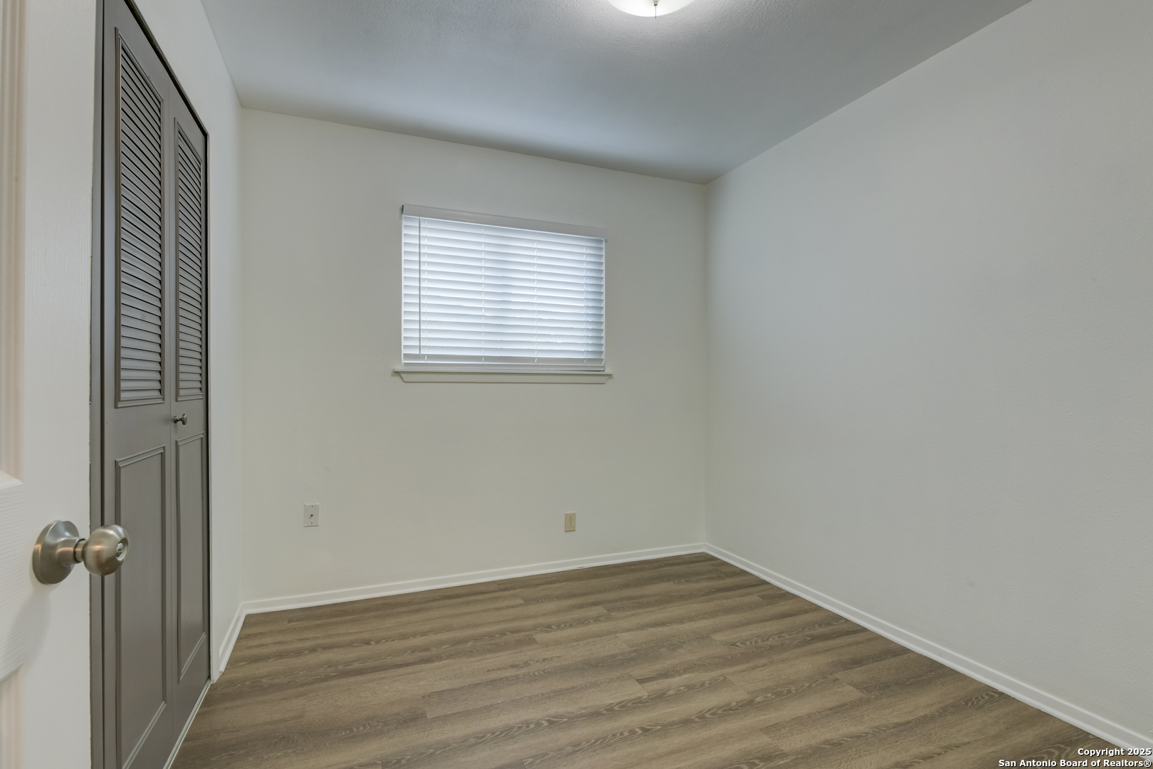 1044 Richmond Drive Schertz, TX 78154 - Photo 19 of 23 an empty room with wooden floor and windows