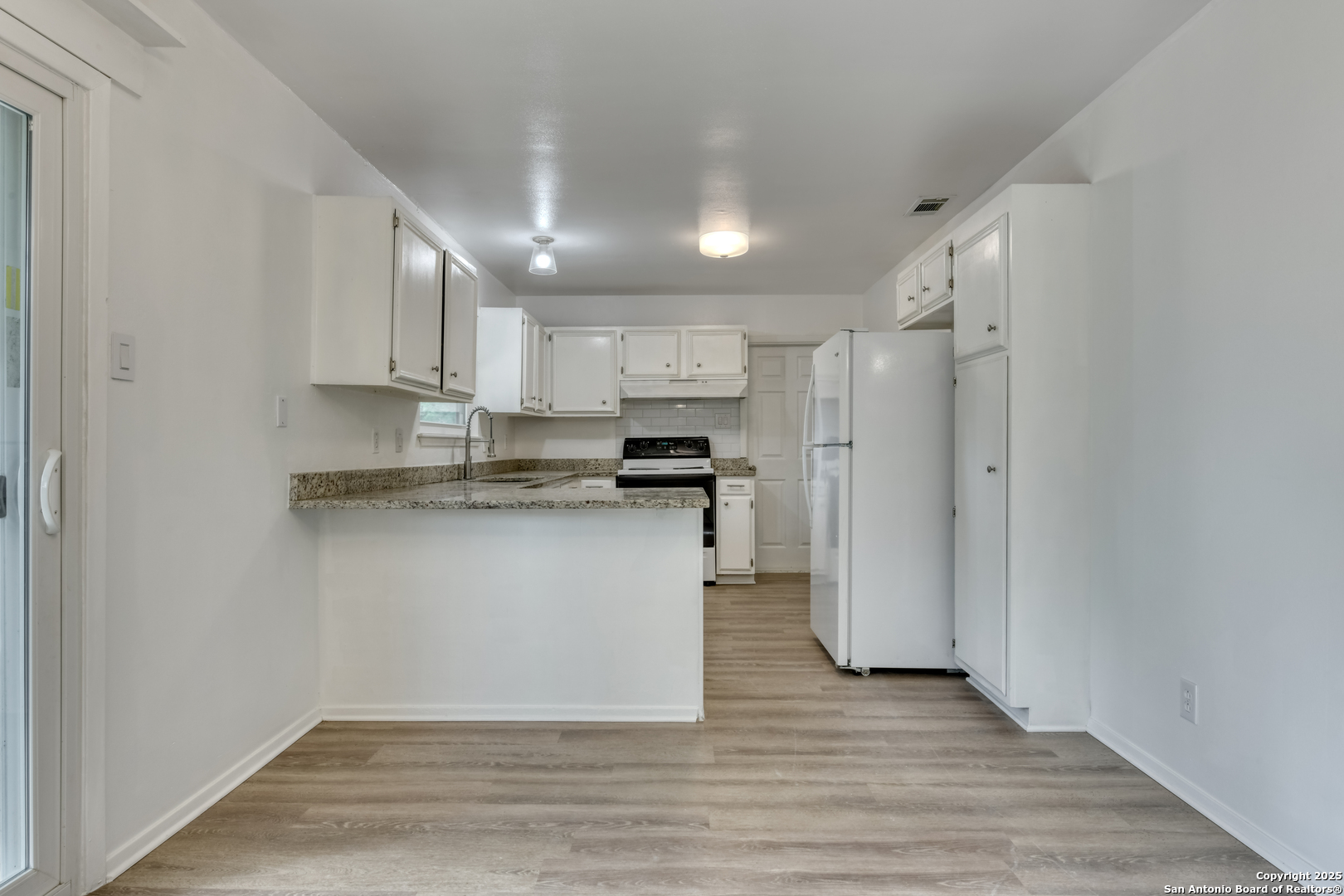 1044 Richmond Drive Schertz, TX 78154 - Photo 7 of 23 a kitchen with stainless steel appliances granite countertop a refrigerator a stove a sink and white cabinets