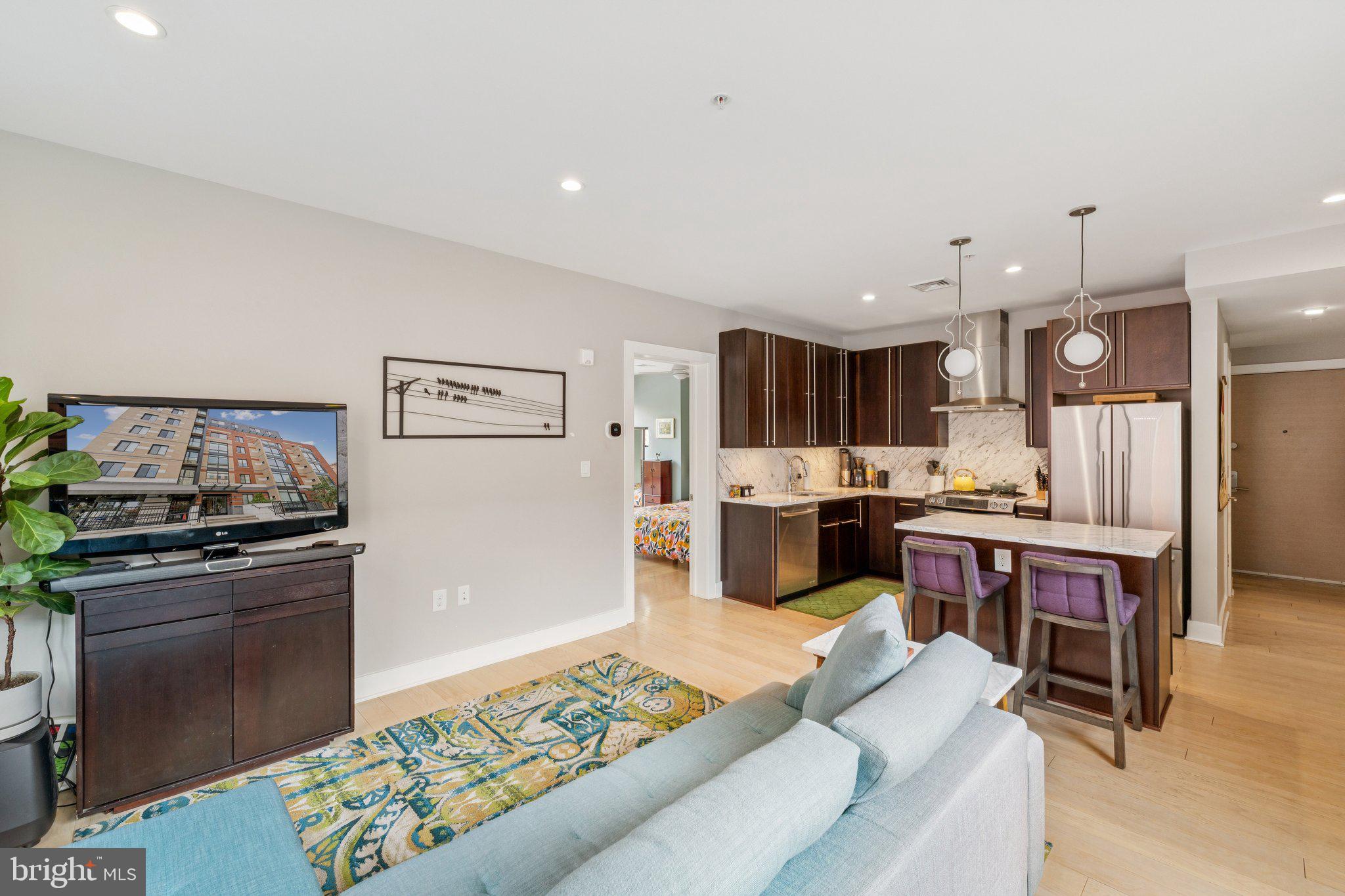 1634 14th Street Northwest, Unit 201 Washington, DC 20009 - Photo 4 of 24 a living room with lots of furniture and kitchen view