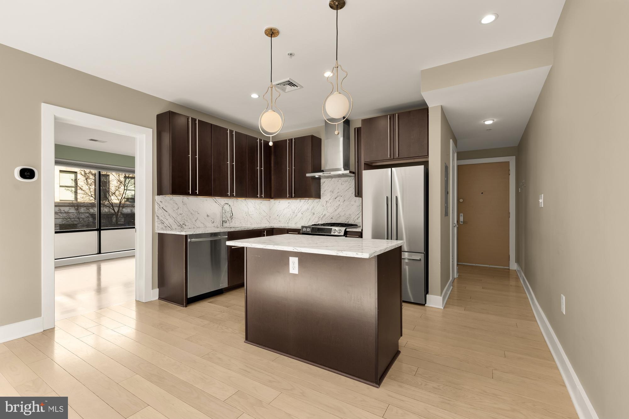 1634 14th Street Northwest, Unit 201 Washington, DC 20009 - Photo 6 of 24 a kitchen with kitchen island a counter space a sink and a refrigerator