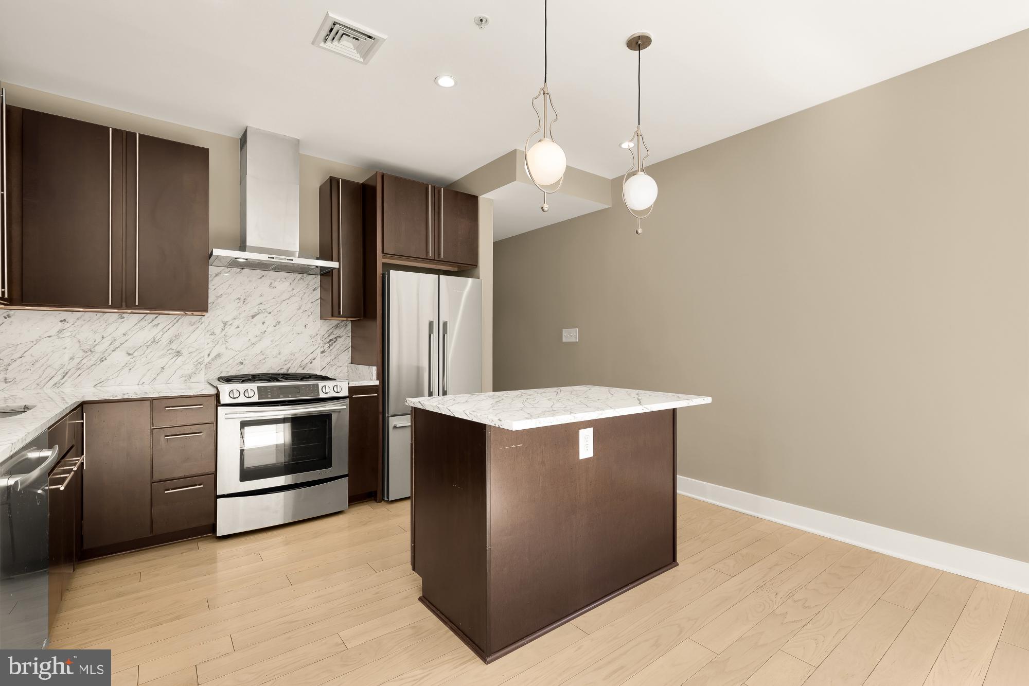 1634 14th Street Northwest, Unit 201 Washington, DC 20009 - Photo 7 of 24 a kitchen with cabinets and stainless steel appliances