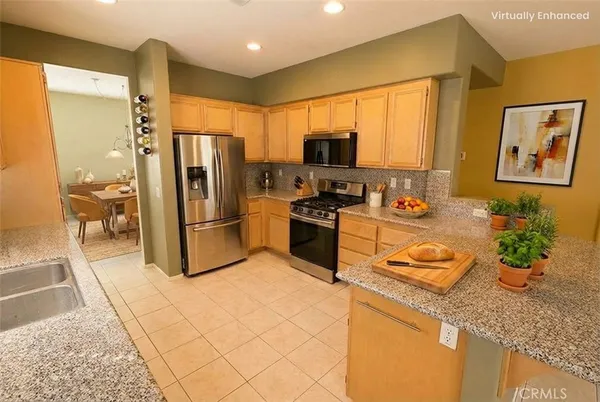 a kitchen with stainless steel appliances granite countertop a refrigerator a sink and a stove