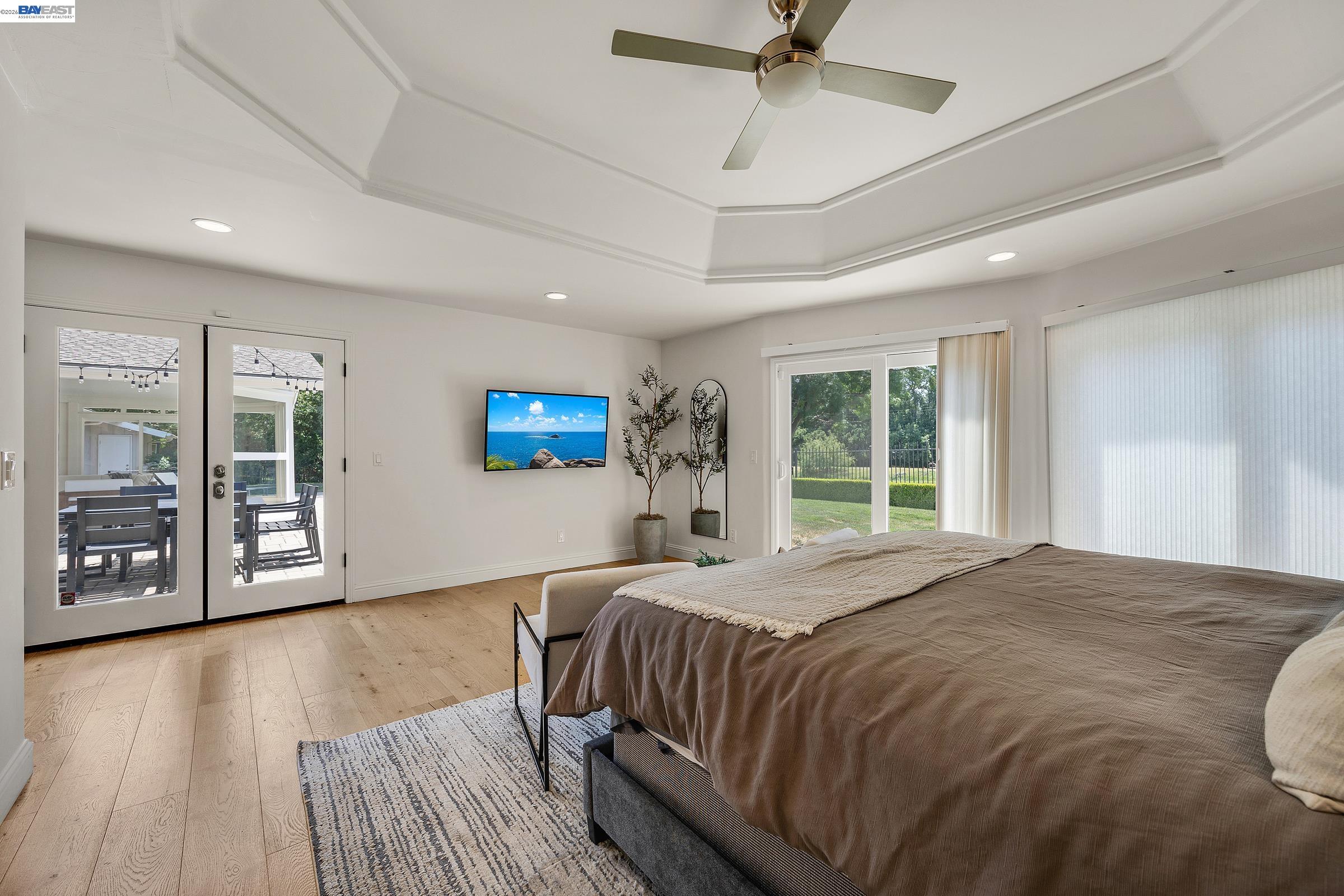 3144 Roundhill Road Alamo, CA 94507 - Photo 28 of 60 a spacious bedroom with a large bed a chandelier and windows