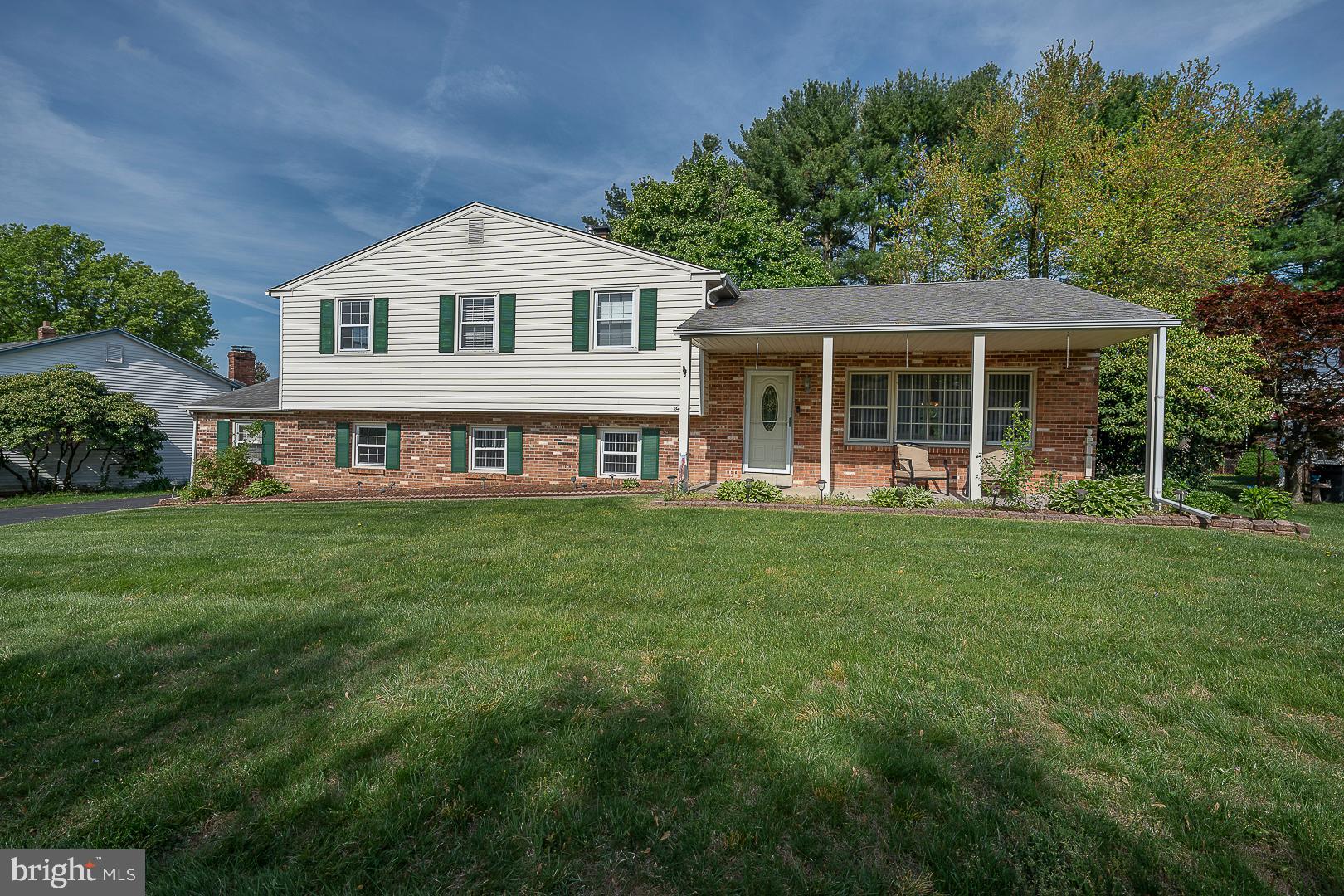 a front view of a house with a yard and green space