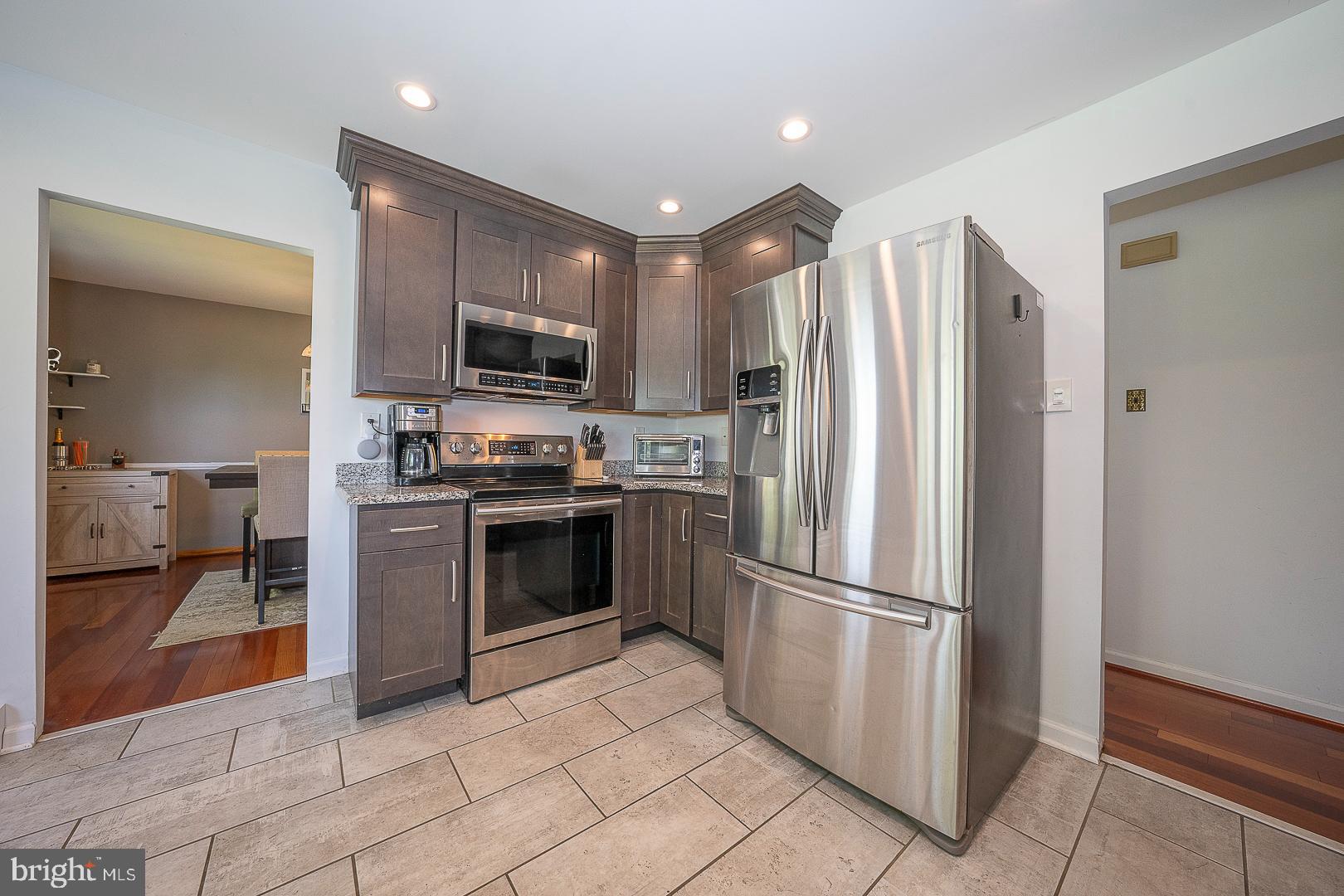 70 Hidden Valley Road Aston, PA 19014 - Photo 19 of 62 a kitchen with granite countertop a refrigerator and a stove top oven