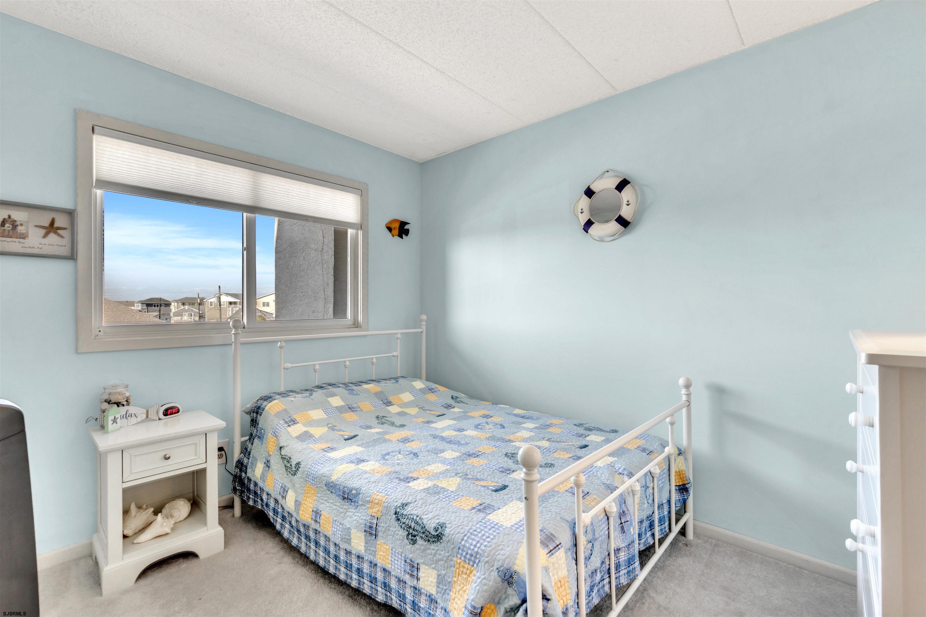 700 East Brigantine Avenue, Unit 2B Brigantine, NJ 08203 - Photo 16 of 36 a bedroom with a bed and a mirror