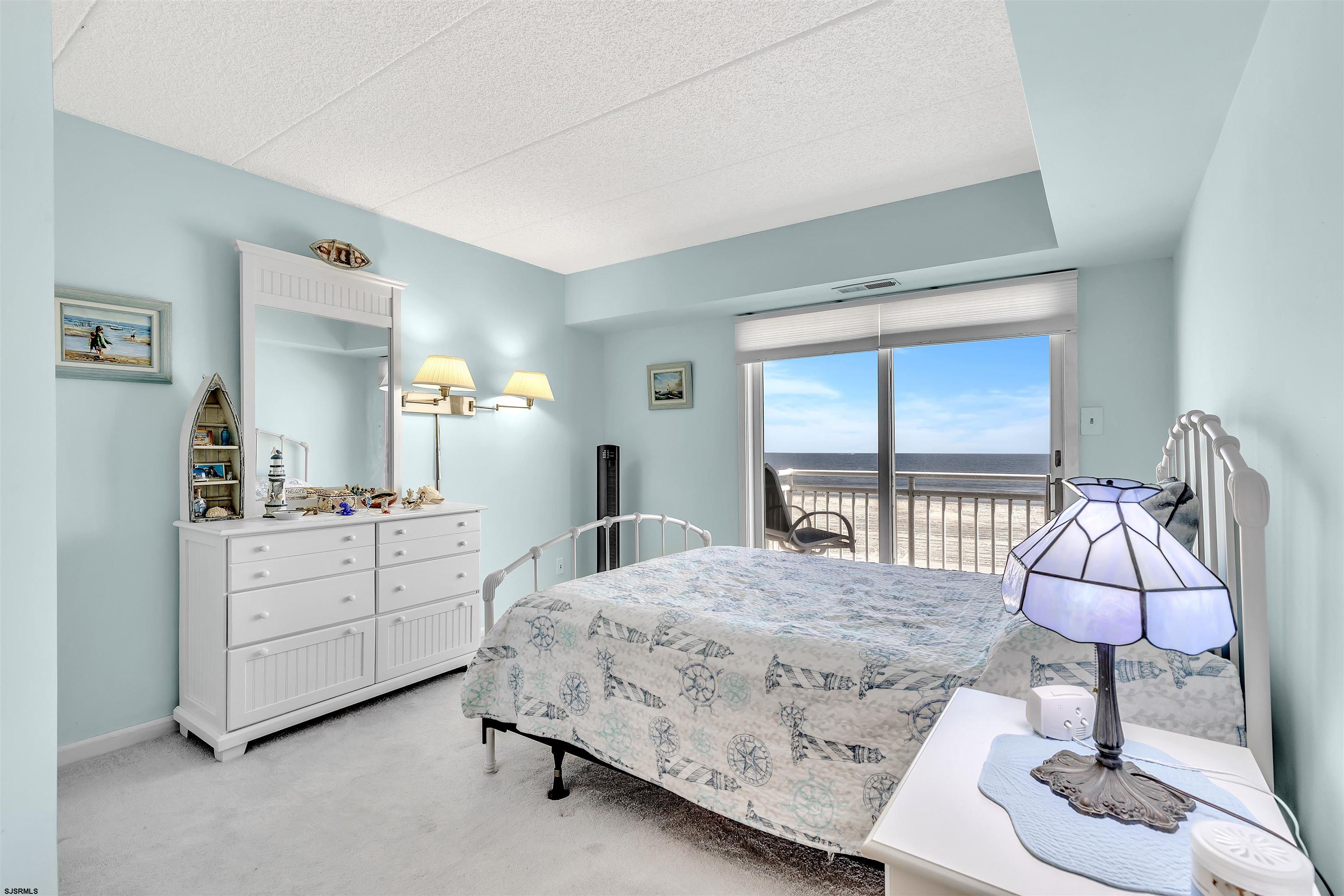 700 East Brigantine Avenue, Unit 2B Brigantine, NJ 08203 - Photo 18 of 36 a bedroom with a bed a chandelier and dresser