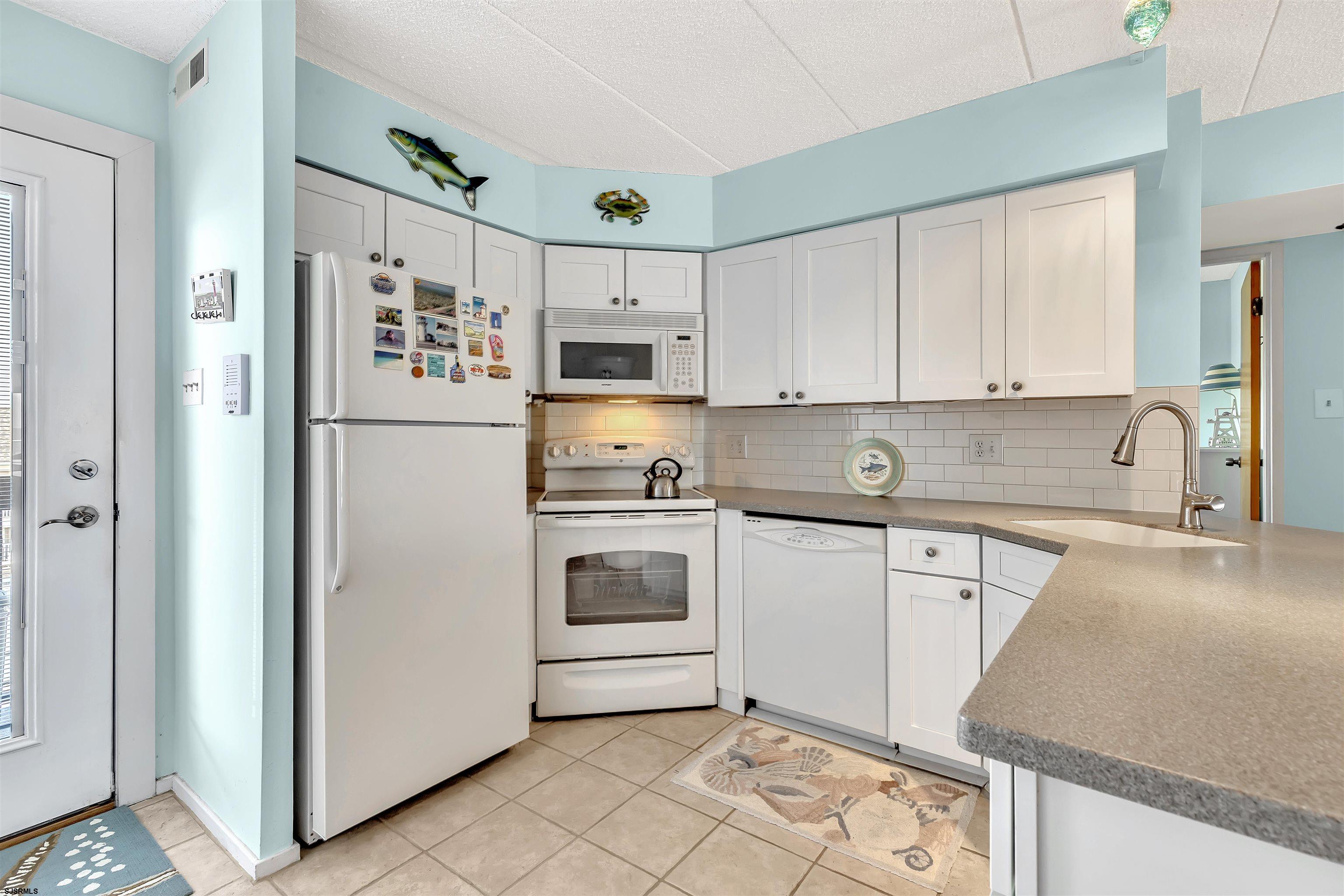 700 East Brigantine Avenue, Unit 2B Brigantine, NJ 08203 - Photo 5 of 36 a kitchen with stainless steel appliances granite countertop a refrigerator sink and white cabinets