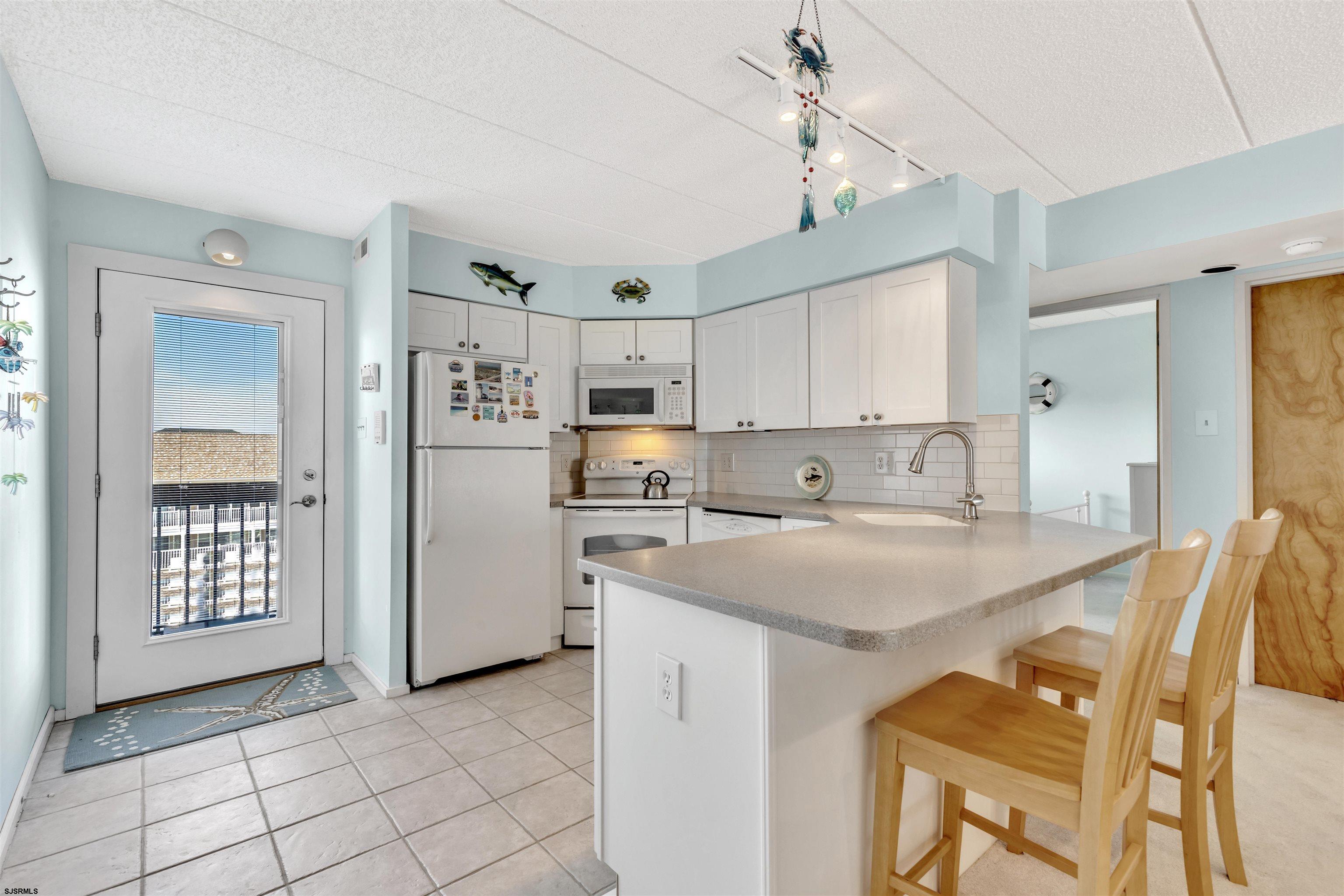 700 East Brigantine Avenue, Unit 2B Brigantine, NJ 08203 - Photo 7 of 36 a kitchen with stainless steel appliances granite countertop a sink a stove a refrigerator cabinets and chairs