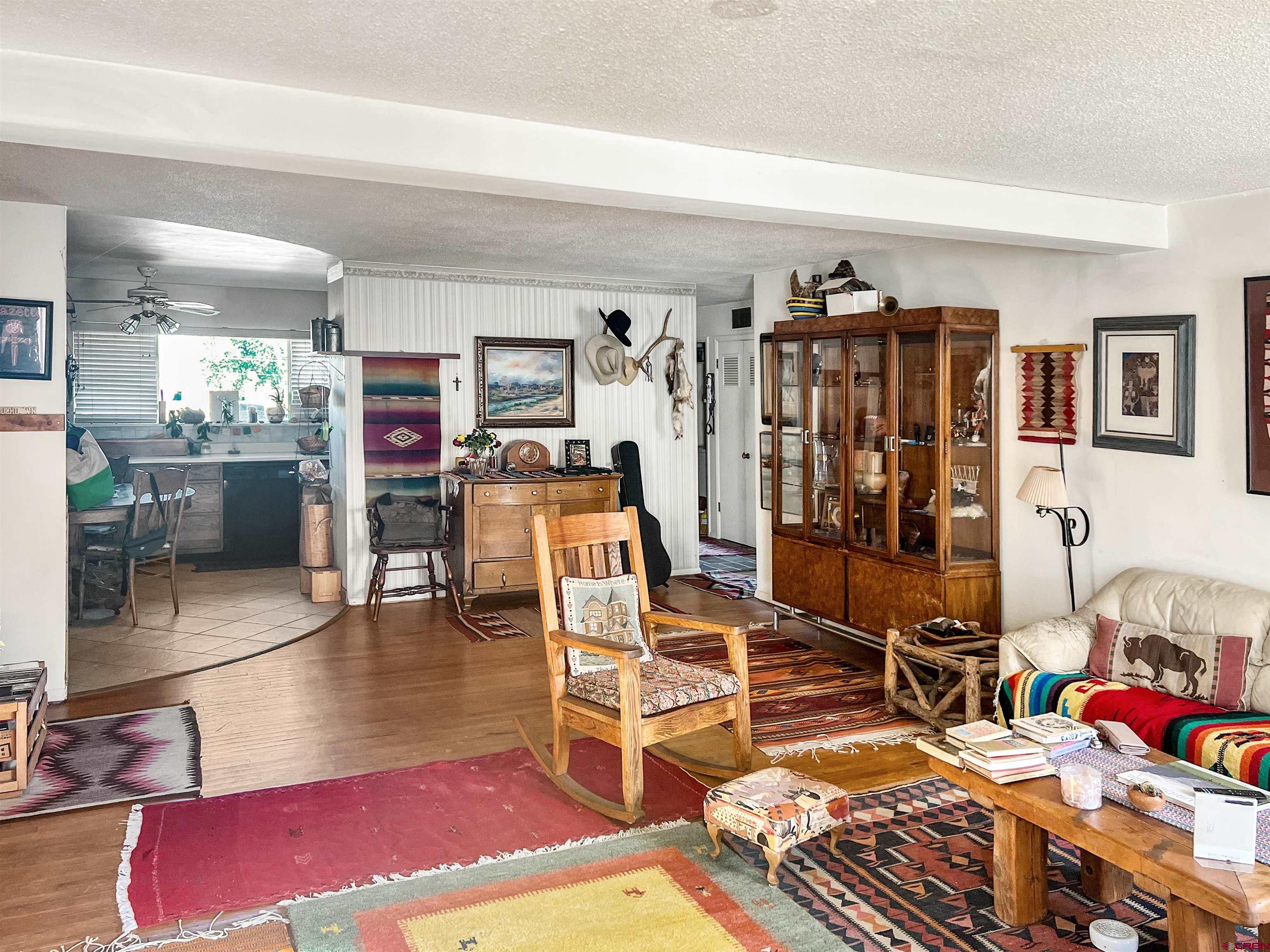 a living room with furniture a rug and gym equipment