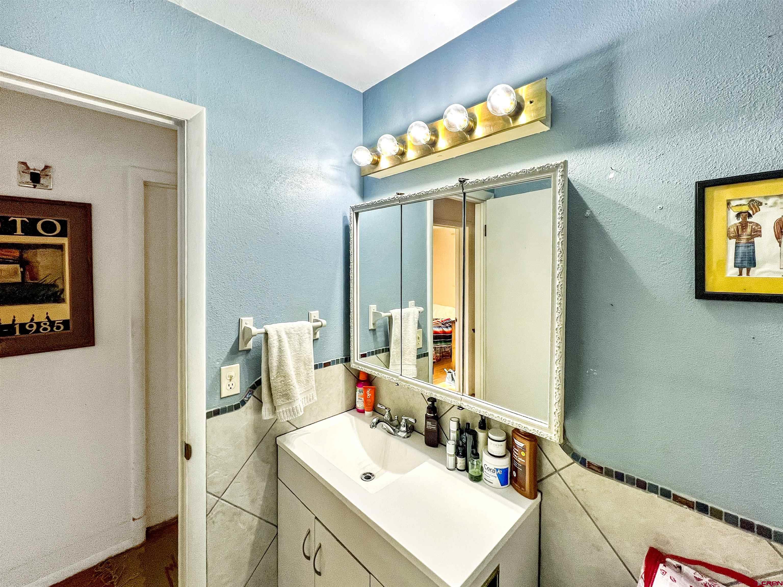1005 South Cedar Street Cortez, CO 81321 - Photo 14 of 19 a bathroom with a sink vanity and a mirror