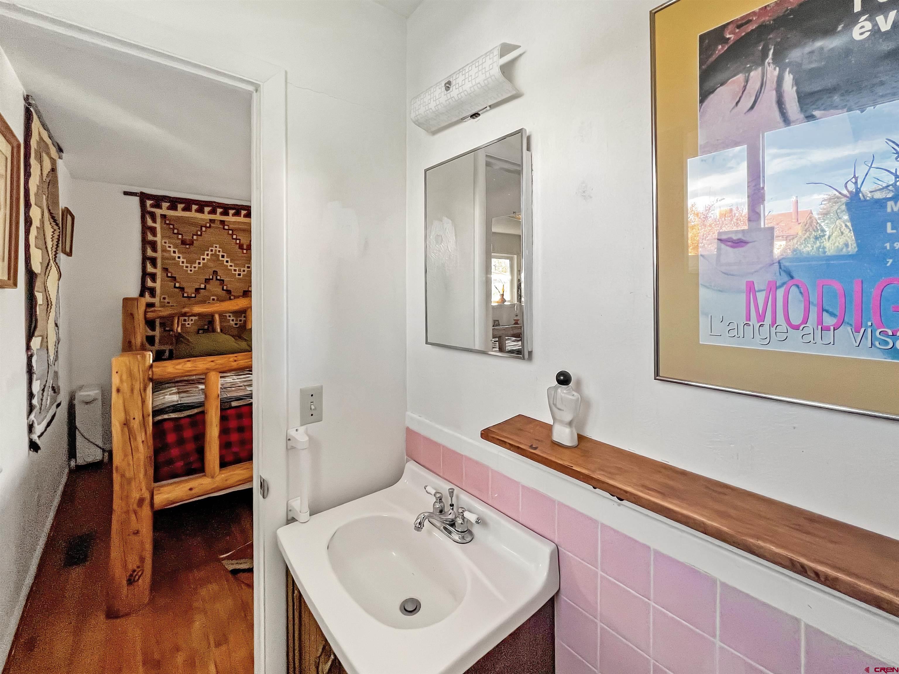 1005 South Cedar Street Cortez, CO 81321 - Photo 4 of 19 a bathroom with a sink and a mirror