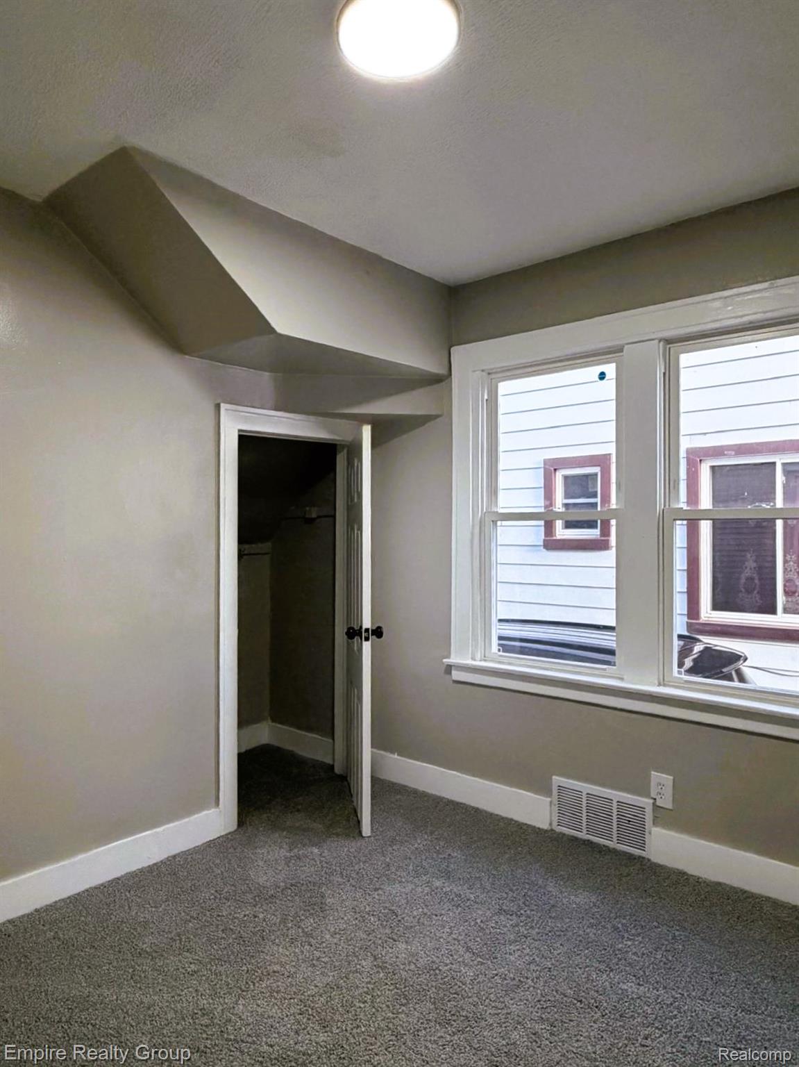 6441 Appoline Street, Unit 1 Dearborn, MI 48126 - Photo 11 of 13 Unfurnished bedroom featuring a closet, carpet flooring, and lofted ceiling