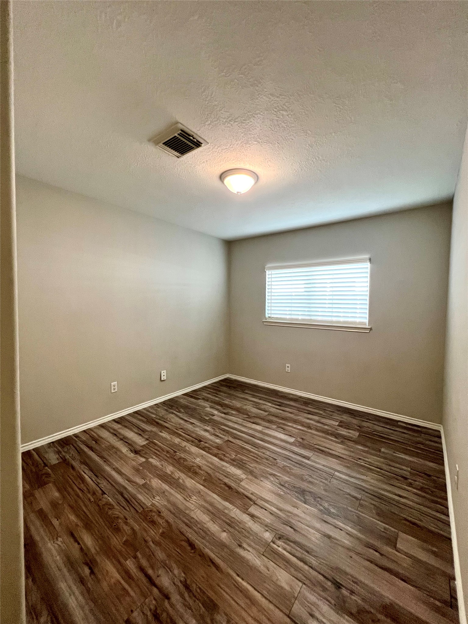 4414 Kulkarni Street Houston, TX 77045 - Photo 5 of 18 a view of an empty room with wooden floor and a window