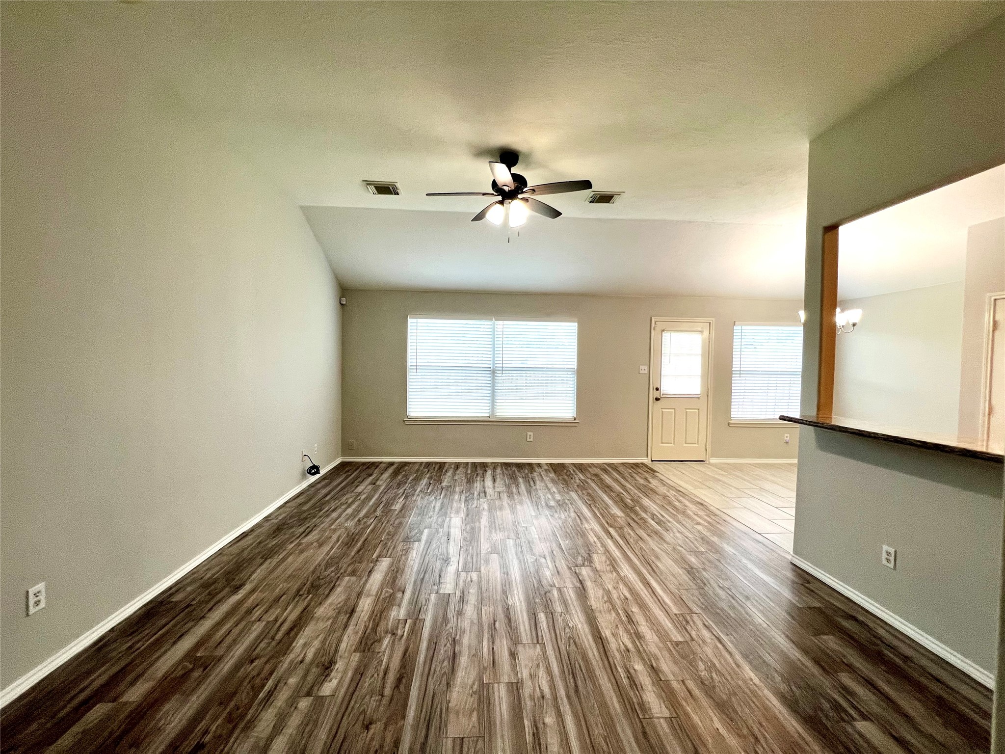 4414 Kulkarni Street Houston, TX 77045 - Photo 8 of 18 a view of an empty room with a window and wooden floor