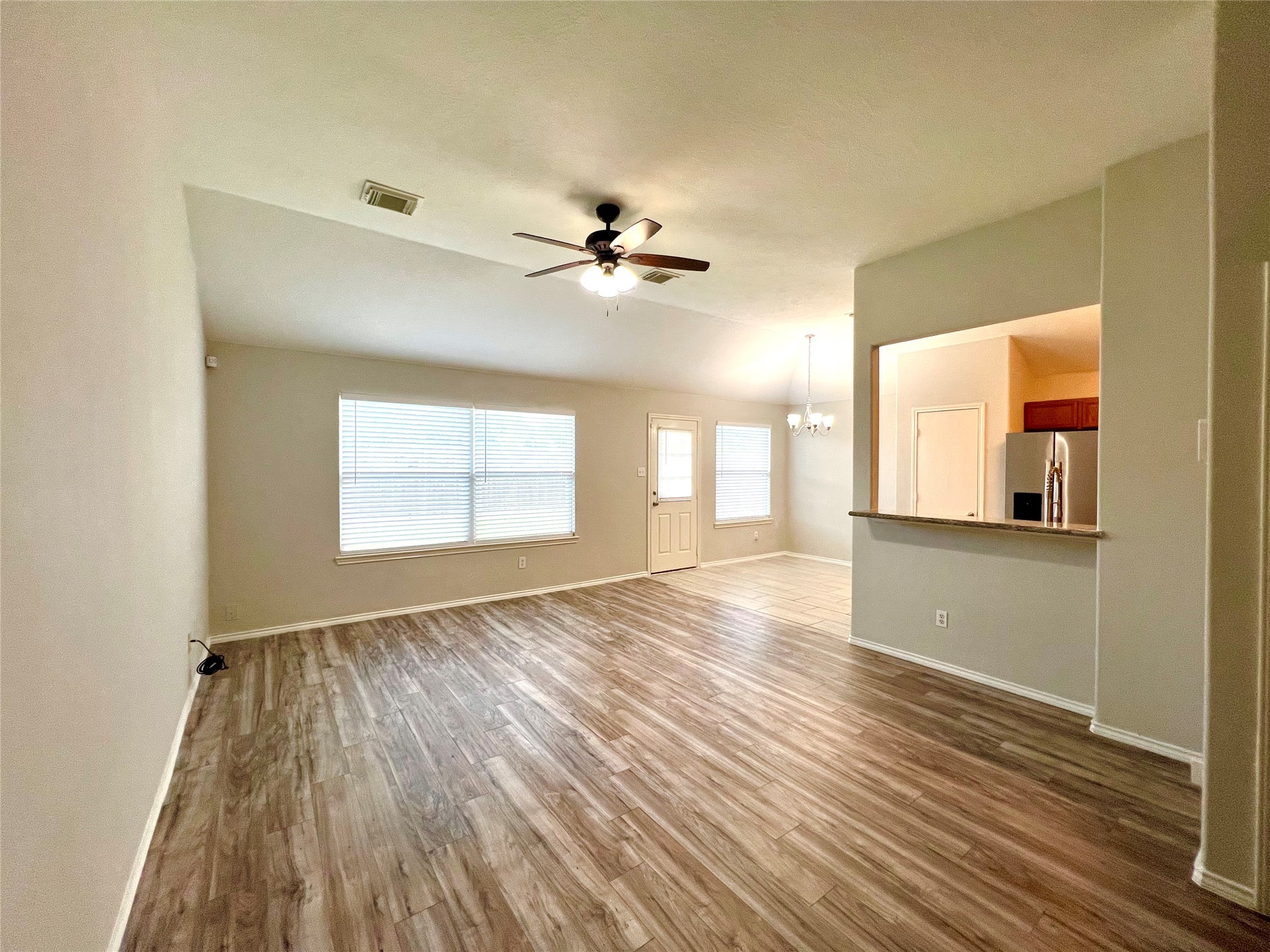 4414 Kulkarni Street Houston, TX 77045 - Photo 9 of 18 a view of an empty room with window and wooden floor