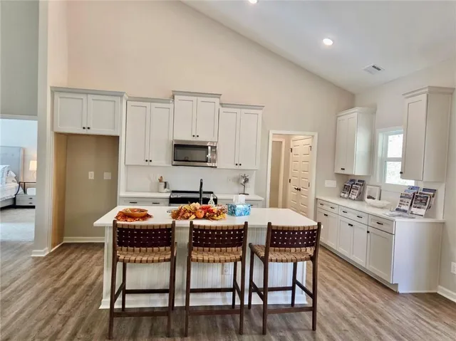 a kitchen with stainless steel appliances a white table and chairs in it