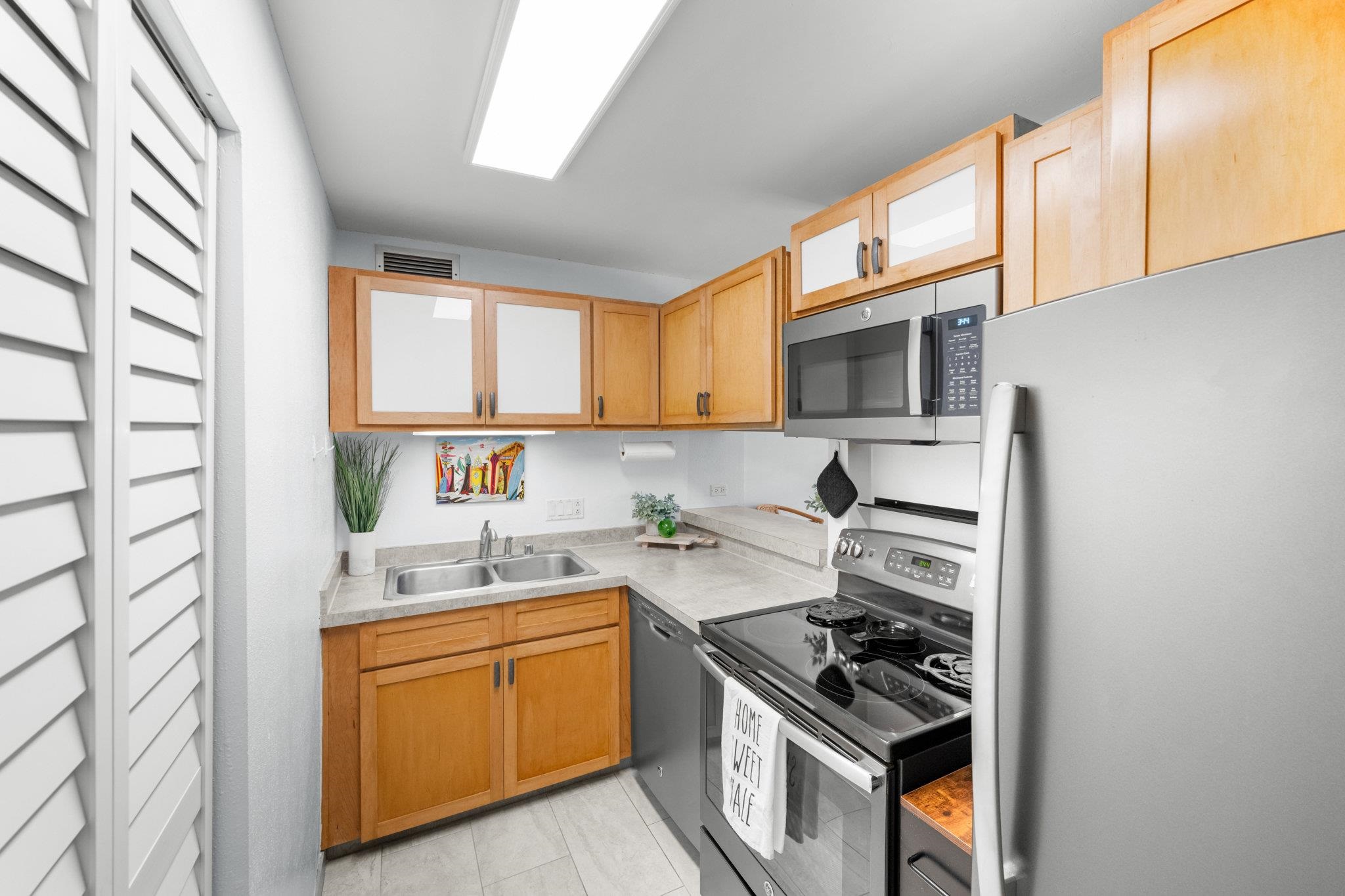 4242 Lower Honoapiilani Road, Unit E304 Lahaina, HI 96761 - Photo 16 of 34 a kitchen with stainless steel appliances a sink stove and cabinets