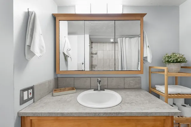 a bathroom with a granite countertop sink and a mirror