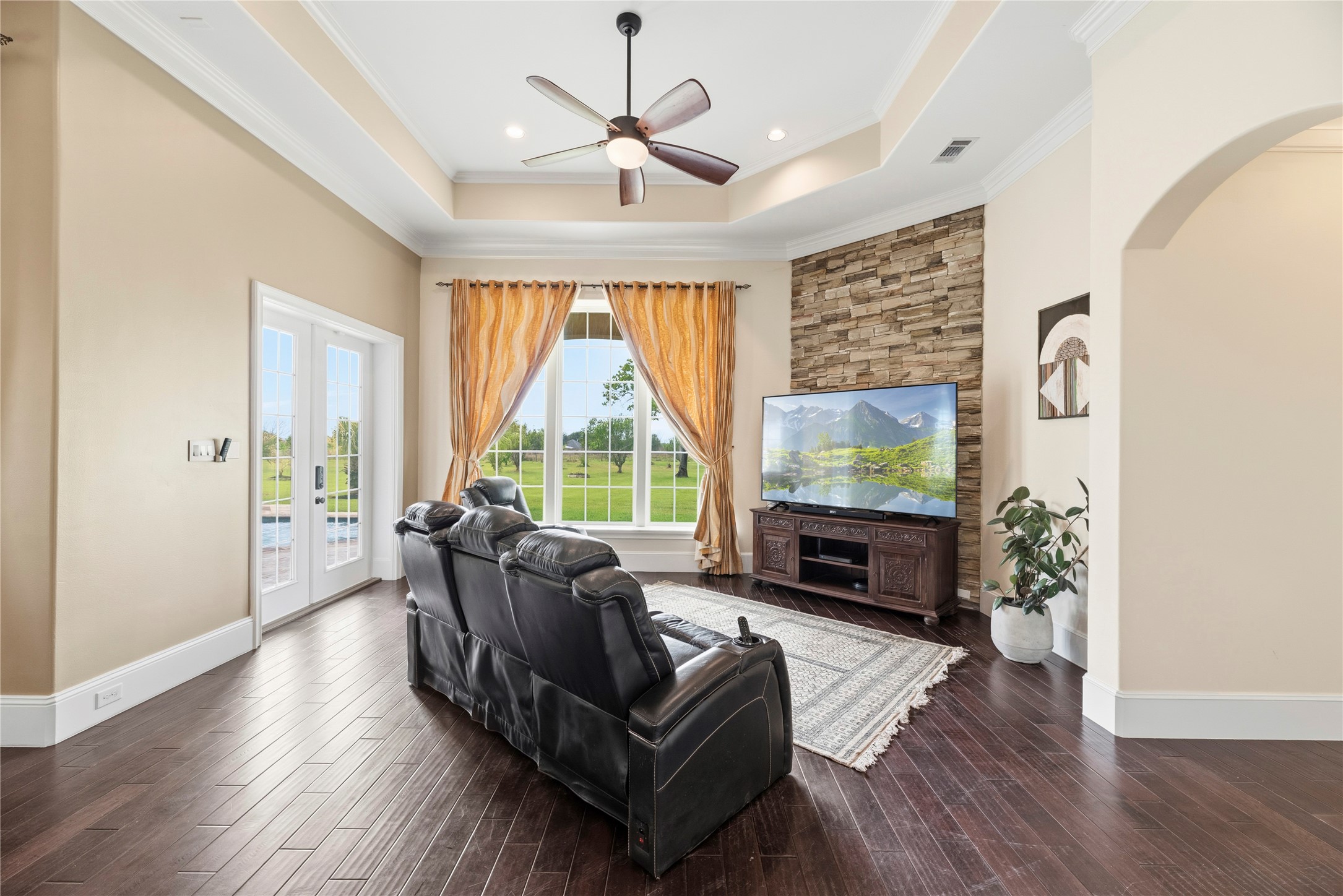 6306 Farm To Market 359 Fulshear, TX 77441 - Photo 12 of 44 Centered by a custom stone feature wall, this light-filled family room integrates seamlessly with the gourmet kitchen and offers direct access to the poolside oasis.