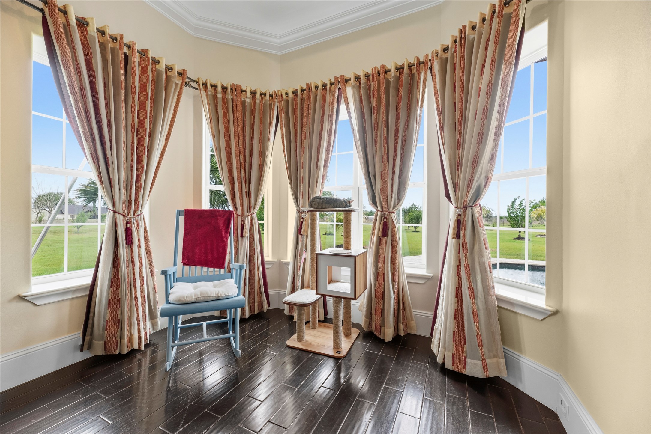 6306 Farm To Market 359 Fulshear, TX 77441 - Photo 18 of 44 A deeper look into the primary bedroom showcases a grand bay of low-E safety glass windows defines this light-filled sitting area, providing a serene environment for quiet reflection overlooking the manicured grounds.