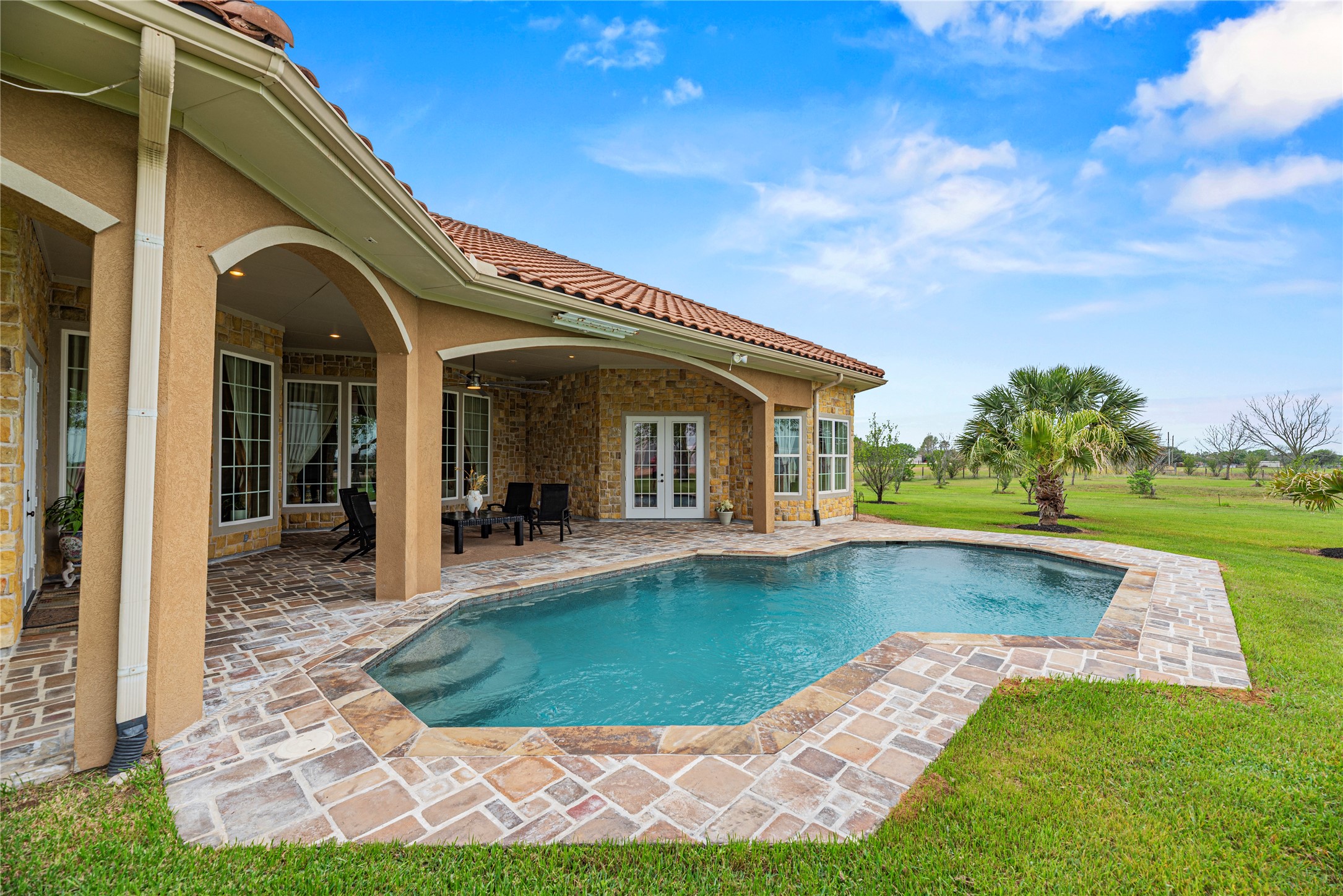 6306 Farm To Market 359 Fulshear, TX 77441 - Photo 30 of 44 The pool features a piped water supply integrated with the exterior water system. This advanced design ensures the surrounding grounds remain a lush and vibrant private oasis while maintaining the pool's freshwater levels.