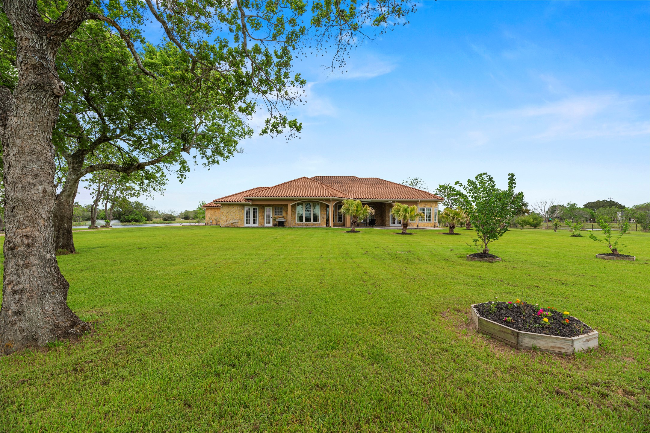 6306 Farm To Market 359 Fulshear, TX 77441 - Photo 32 of 44 The manicured backyard provides vast open space for recreation and livestock, featuring mature pecan and fruit trees and a full-property automatic sprinkler system.